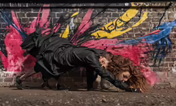 woman laying on ground in front of graffiti painted wall