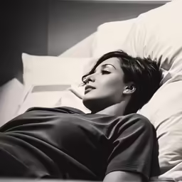 a black and white image of a woman laying in bed
