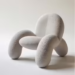 a concrete sculpture of three curved legs