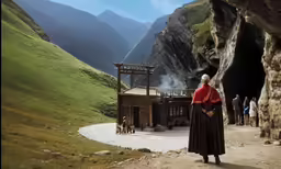 a woman in an old time clothes and red jacket looking out over the landscape