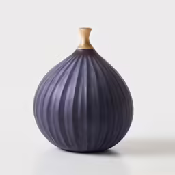 the base of a dark colored round vase on a white surface