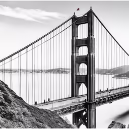 the view of a bridge on top of a hill in black and white