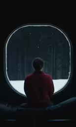 a person sitting by an open window at night