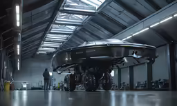 two people working on an airplane in a garage