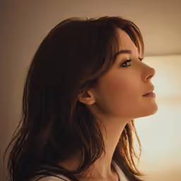 a beautiful young woman is looking out the window