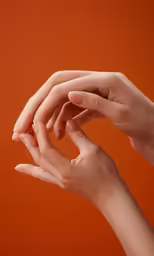 two hands reaching into the air with an orange background