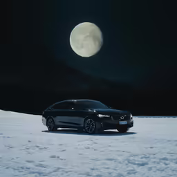 black bmw on snow with a full moon in the sky