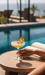the person is enjoying their beverage near the pool