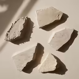 four pieces of cement sit in a pattern on a wall
