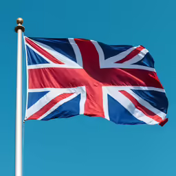 a large british flag on top of a metal pole
