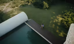 a woman sitting at the end of a floating dock next to a pond