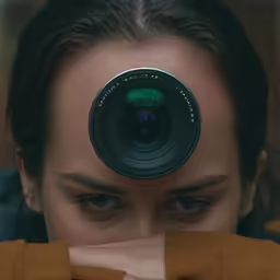 a girl looking through the lens of her camera