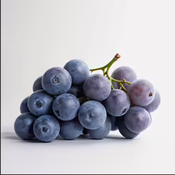 a bunch of grapes with leaves sitting on top