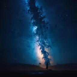 a person standing under the stars on a night sky