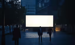 three people walking on a city street under a large billboard