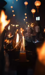several lit candles sitting in small bowls with light bulb hanging in the background