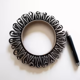 a pen resting inside of an ornate metal bracelet