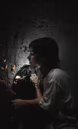 a girl is standing next to a black thing that appears to be falling from the ceiling