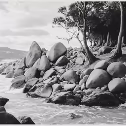 large rocks along the beach are washed by the surf