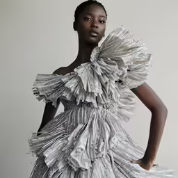 a woman wearing a dress made of papers