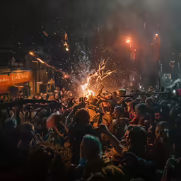a crowd is gathered in front of a large fire and fireworks