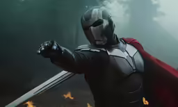a man in armor holding a sword and wearing a cape