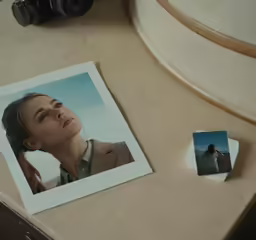 a polaroid with an image of a woman is placed on a counter