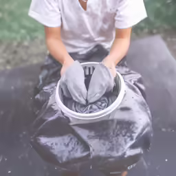 a person with their hands on a cup and cloth