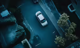 an aerial view of cars parked on the side of a road