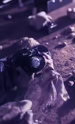 a man that is standing in the dirt taking a picture