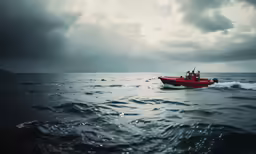 a red boat in a big body of water