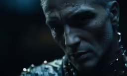 the face of an evil character with chain mails around his neck