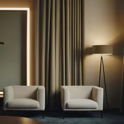 two chairs are facing each other near a lamp