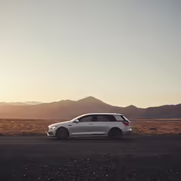 the front end of a silver car on the road