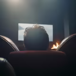 the back of someones head sitting on a red chair