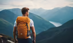 a man with his backpack on is overlooking mountains
