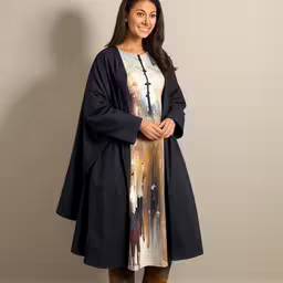 the woman is smiling and posing with her hands in her pockets