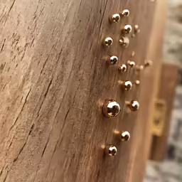 some gold hardware are on the wooden side