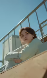 the woman is sitting on the side of a wooden ramp