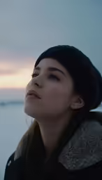 a woman in a hat staring into the distance