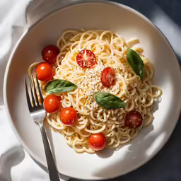 a plate of pasta with tomatoes and a pesto on it