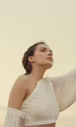 the model is posing on the beach in a crop top