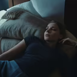 a woman laying on top of pillows in bed