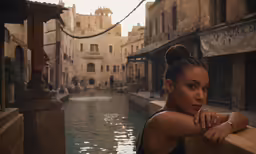 a woman leaning against a rail looking down at the water