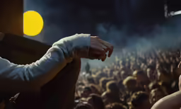 man with hands crossed over cross with yellow light in background