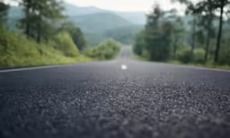 a black asphalt road with white dots in the middle