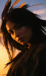 the woman with bird feathers on her head is in front of a sunset