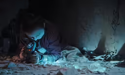 a man looking at his camera while working on something