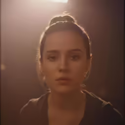 the young woman has dark hair and is posing for the camera