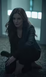 the woman is kneeling down wearing a suit